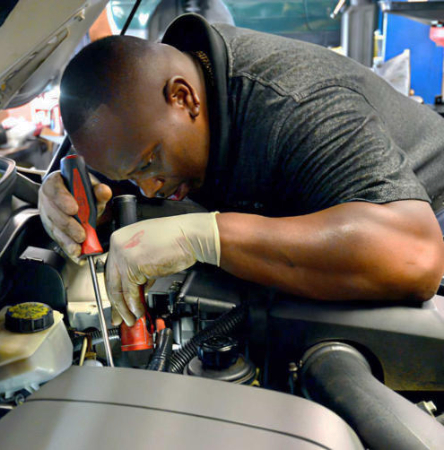 Mechanic checking car with tools